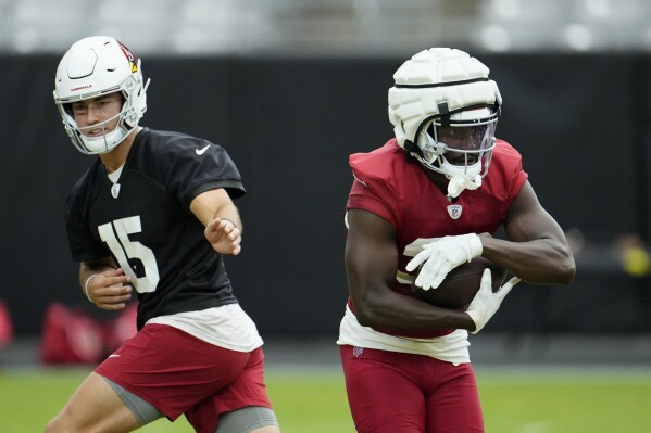 Arizona Cardinals quarterback Clayton Tune (15) hands the ball off to running back Marlon Mack during NFL football training camp practice at State Farm Stadium, Monday, Aug. 7, 2023, in Glendale, Ariz. (AP Photo/Ross D. Franklin)