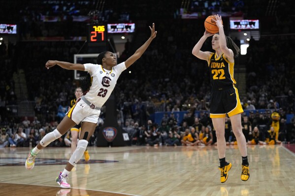 Iowa guard Caitlin Clark (22) shoots over South Carolina guard Bree Hall (23) during the first half of the Final Four college basketball championship game in the women's NCAA Tournament, Sunday, April 7, 2024, in Cleveland. (AP Photo/Carolyn Kaster)