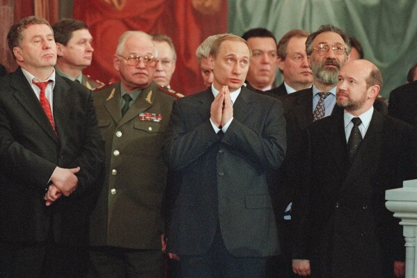 Vladimir Putin, center, attends a Christmas service in Christ the Savior Cathedral in Moscow, Jan. 8, 2000. (AP Photo/Misha Japaridze, File)