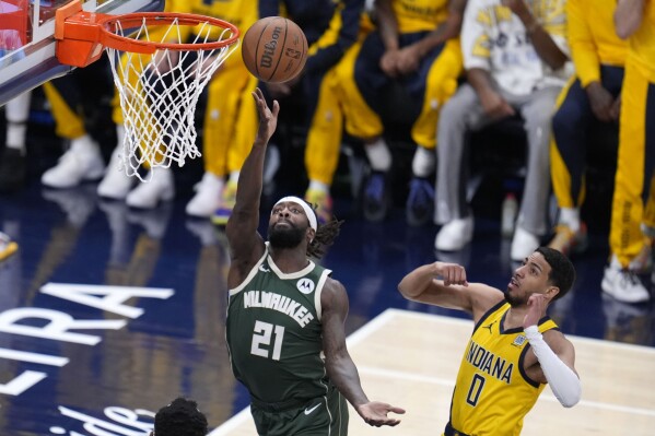 Milwaukee Bucks guard Patrick Beverley (21) drives to the basket past Indiana Pacers guard Tyrese Haliburton (0) during the first half in Game 6 in an NBA basketball first-round playoff series, Thursday, May 2, 2024, in Indianapolis. (AP Photo/Michael Conroy)
