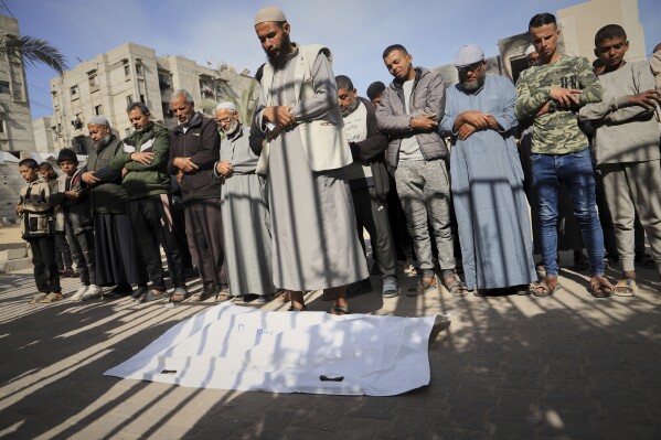 Nashat Seiam, third from right, joins relatives and friends in prayer over the body of his granddaughter Ahlam, who was just days away from her first birthday, during her funeral after she was killed by an overnight Israeli airstrike on her home in Khan Younis, southern Gaza Strip, on Wednesday, April 16, 2025,.(AP Photo/Mariam Dagga)
