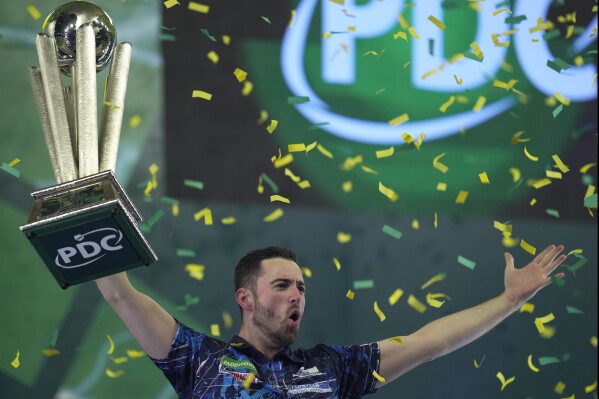 Luke Humphries of England celebrates after winning the final match against Luke Littler of England at the World Darts Championship, in London, Wednesday, Jan. 3, 2024. (AP Photo/Kin Cheung)