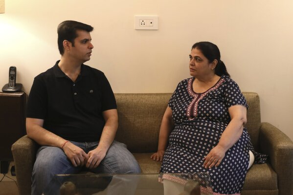 Karan Murgai, left, an IT management consultant for a multinational based in Dallas, talks to his mother Ushmi Murgai, at their home, in New Delhi, India, Tuesday, June 30, 2020. Murgai came to Delhi in March this year after his father died. Murgai and at least 1,000 others like him, whose U.S. visas are tied to their jobs in the U.S., are now stranded in India, after an executive order signed by President Donald Trump that suspends applications for H-1B and other high-skilled work visas from abroad. (AP Photo/Manish Swarup)