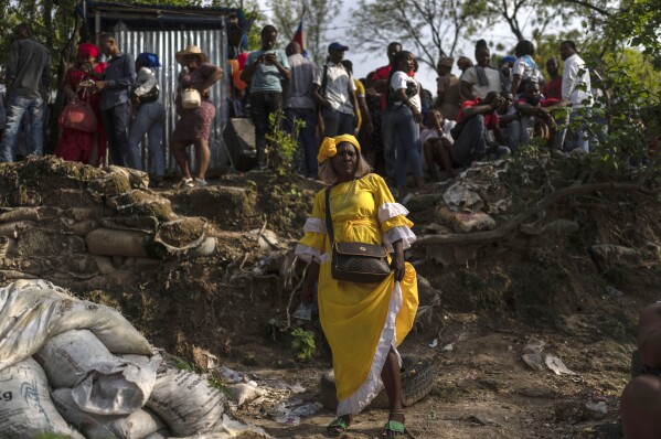 FILE - A Voudist clad in yellow, a color associated with the power of light, poses for a photo during the Saint George celebration in Port-au-Prince, Haiti, April 24, 2024. It’s unknown how many people currently practice Vodou in Haiti, but there’s a popular saying: “Haiti is 70% Catholic, 30% Protestant and 100% Vodou.” (AP Photo/Ramon Espinosa, File)