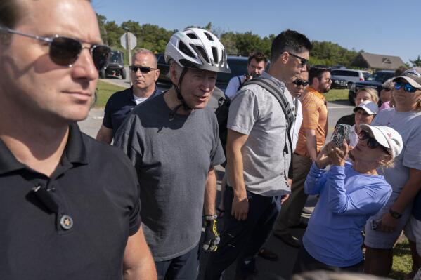 2022年6月18日土曜日、デラウェア州レホボスビーチのゴードンズ池の小道で自転車から転落し、群衆に話しかける米国秘密情報部職員に囲まれたジョー・バイデン大統領。バイデン大統領は週末をレホボスビーチの自宅で過ごしている。 (AP写真/マヌエル・バルセ・セネタ)