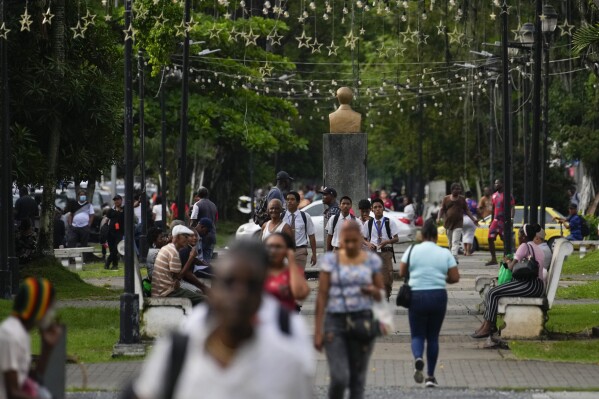 People walk along Central Avenue in Colon, Panama, Monday, Sept. 4, 2023. The Sept. 3 shooting death of national soccer team player Gilberto Hernandez in Colon has brought to light the high levels of violence in this port city where large ships move in and out of the Panama Canal. (AP Photo/Arnulfo Franco)