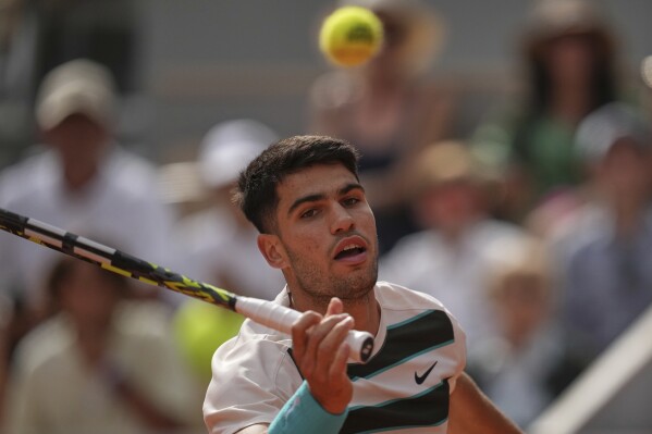 Spain's Carlos Alcaraz returns the ball to Ben Shelton of the U.S. during their fourth round match of the French Tennis Open, at the Roland-Garros stadium, in Paris, Sunday, June 1 2025. (AP Photo/Christophe Ena)