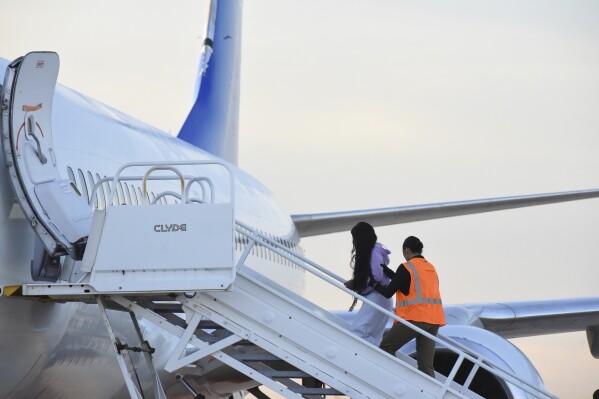 Venezuelan migrants board a plane heading back to their home country from Harlingen, Texas, on Wednesday, Oct. 18, 2023. U.S. immigration officials say passengers chosen for the deportation flight included recent arrivals as well as migrants who have committed crimes in the U.S. (AP Photo/Valerie Gonzalez)