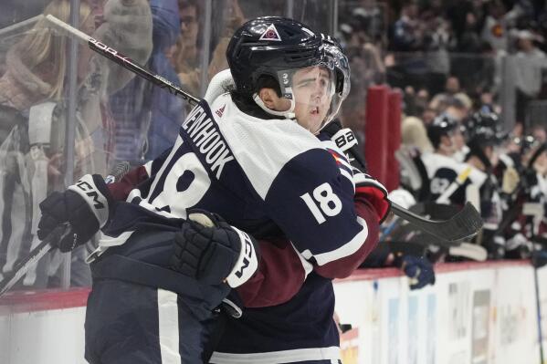 Colorado Avalanche center Alex Newhook, front, is hugged by center Andrew Cogliano after scoring a goal in the first period of an NHL hockey game against the St. Louis Blues, Saturday, Jan. 28, 2023, in Denver. (AP Photo/David Zalubowski)