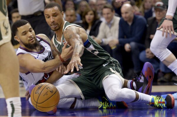 Toronto Raptors guard Fred VanVleet, left, vies for the ball with Milwaukee Bucks guard George Hill during the second half of an NBA basketball game Tuesday, Feb. 25, 2020, in Toronto. (Nathan Denette/The Canadian Press via AP)