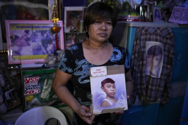 Emily Soriano holds a picture of her 15-year-old son as she recounts how he was gunned down with four friends and two other residents while partying in a Philippine slum six years ago during an interview with the Associated Press at their home in Manila, Philippines on June 23, 2022. With Philippine President Rodrigo Duterte set to step down on June 30, 2022 at the end of his turbulent six-year term, Soriano and other relatives, who say their loved ones were victims of extrajudicial killings under Duterte's campaign, are turning to the International Criminal Court after failing for years to attain justice at home. (AP Photo/Aaron Favila)