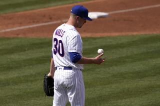Chicago Cubs starting pitcher Alec Mills flips the ball after giving up a run during the second inning of a spring training baseball game against the Colorado Rockies, Friday, March 25, 2022, in Mesa, Ariz. (AP Photo/Matt York)