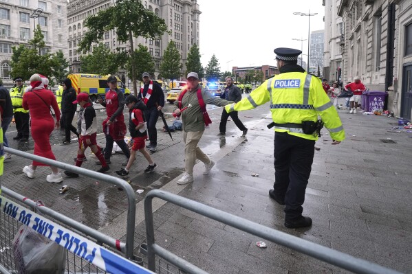 Fans leave as Police and emergency personnel deal with an incident near the Liver Building during the Premier League winners parade in Liverpool, England, Monday, May 26, 2025.(AP Photo/Jon Super)