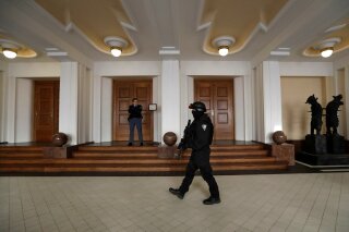 FILE - In this Friday, Nov. 24, 2017 file photo, a prison guard walks outside a courtroom during an appeal by Yevgeniy Nikulin from Russia who faces charges of hacking computers of American companies, in Prague, Czech Republic. The Czech Republic extradited a Russian man to the U.S. to face charges of hacking computers at LinkedIn, Dropbox and other American companies, an official said Friday March 30, 2018. Yevgeniy Nikulin was flown to the U.S. overnight, Justice Ministry spokeswoman Tereza Schejbalova said. (AP Photo/Petr David Josek)