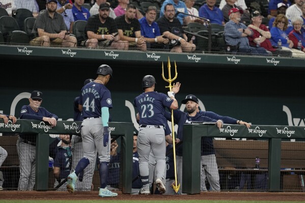 Seattle Mariners' Ty France (23) and Julio Rodriguez (44) celebrate at the dugout entrance after France hit a two-run home run that also cored Julio Rodriguez (44) in the first inning of a baseball game against the Texas Rangers in Arlington, Texas, Thursday, April 25, 2024. (AP Photo/Tony Gutierrez)