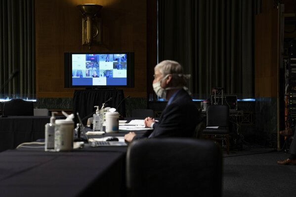 A monitor displays video feeds from members of the Senate Health Education Labor and Pensions Committee via teleconference during a Senate Health Education Labor and Pensions Committee hearing on new coronavirus tests on Capitol Hill in Washington, Thursday, May 7, 2020. National Institutes of Health Director Dr. Francis Collins, looks on at right. (Anna Moneymaker/The New York Times via AP, Pool)