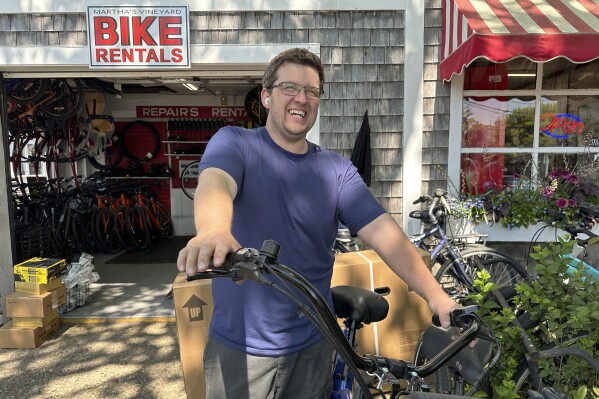 Jason Merrill, owner of Martha's Vineyard Bike Rentals, poses outside his store, Tuesday, June 4, 2024, in Edgartown, Massachusetts. High housing costs on Martha's Vineyard are forcing many regular workers to leave and are threatening public safety. (AP Photo/Nick Perry)