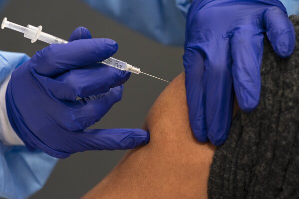 In this Thursday, Feb. 11, 2021, photo a person receives their second dose of the COVID-19 vaccine at a clinic at Howard University, in Washington. (AP Photo/Jacquelyn Martin)