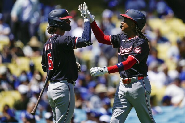 Washington Nationals' CJ Abrams, right celebrates with Jesse Winker after hitting a solo home run during the first inning of a baseball game against the Los Angeles Dodgers, Wednesday, April 17, 2024, in Los Angeles. (AP Photo/Ryan Sun)