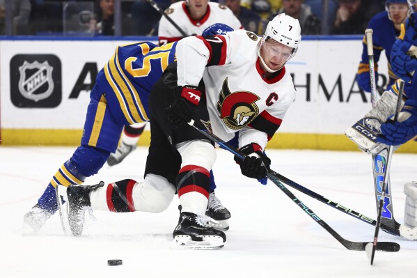 Ottawa Senators left wing Brady Tkachuk (7) skates past the puck during the second period of an NHL hockey game against the Buffalo Sabres Wednesday, March 27, 2024, in Buffalo, N.Y. (AP Photo/Jeffrey T. Barnes)
