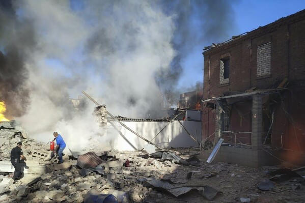 In this photo provided by the Ukrainian Emergency Service, people work to extinguish a fire following a Russian attack in Kryvyi Rih, Ukraine, Friday, Sept. 8, 2023. (Ukrainian Emergency Service via AP)