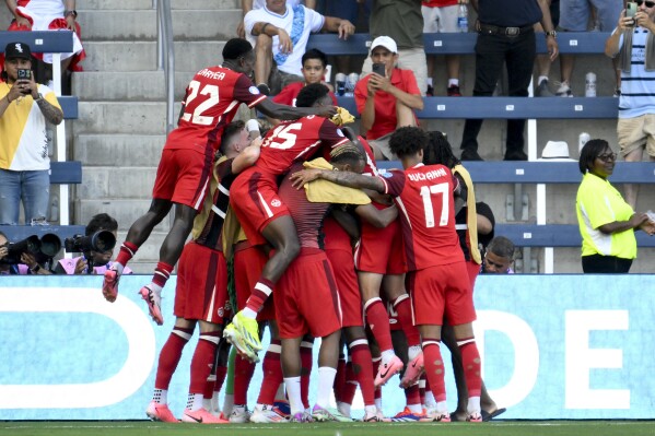  Canada's Jonathan David, not seen, celebrates scoring the opening goal against Peru with teammates during a Copa America Group A soccer match in Kansas City, Kan., Tuesday, June 25, 2024. (AP Photo/Reed Hoffmann)