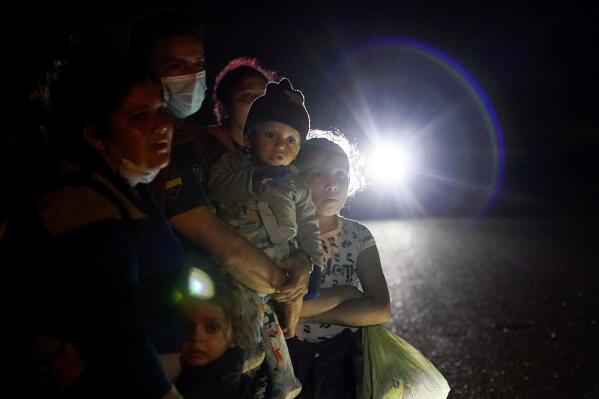 FILE - A group of migrants mainly from Honduras and Nicaragua wait along a road after turning themselves in upon crossing the U.S.-Mexico border, in La Joya, Texas, May 17, 2021. Biden took office on Jan. 20 and almost immediately, numbers of migrants exceeded expectations. (AP Photo/Gregory Bull, File)