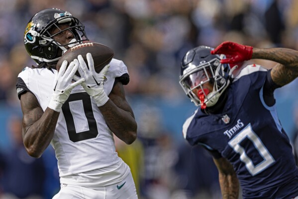 FILE - Jacksonville Jaguars wide receiver Calvin Ridley (0) catches a pass in front of Tennessee Titans cornerback Sean Murphy-Bunting (0) during their NFL football game Sunday, Jan. 7, 2024, in Nashville, Tenn. Ridley and the Tennessee Titans have agreed on a four-year, $92 million contract, a person with knowledge of the terms told The Associated Press on Wednesday, March 13, 2024. (AP Photo/Wade Payne, File)