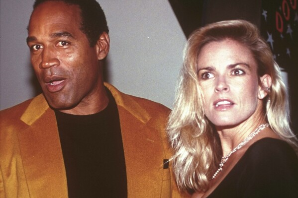 FILE - O.J. Simpson and his wife, Nicole Brown Simpson, arrive for the opening of the Harley-Davidson Cafe in New York on Oct. 19, 1993. Simpson, the decorated football superstar and Hollywood actor who was acquitted of charges he killed Nicole Brown Simpson and her friend but later found liable in a separate civil trial, has died. He was 76. (AP Photo/Paul Hurschmann, File)