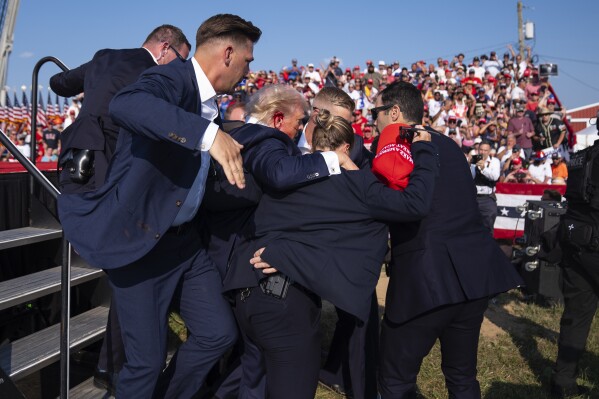 Republican presidential candidate former President Donald Trump is helped off stage by U.S. Secret Service agents at a campaign rally, Saturday, July 13, 2024, in Butler, Pa. (AP Photo/Evan Vucci)