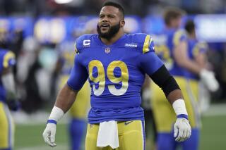 FILE - Los Angeles Rams' Aaron Donald warms up before an NFL wild-card playoff football game against the Arizona Cardinals in Inglewood, Calif., Jan. 17, 2022. All-Pro defensive tackle Donald is getting a big raise to stay with the Rams under a reworked contract through 2024. The Super Bowl champion Rams announced Donald's return Monday, June 6, 2022. (AP Photo/Jae C. Hong, File)