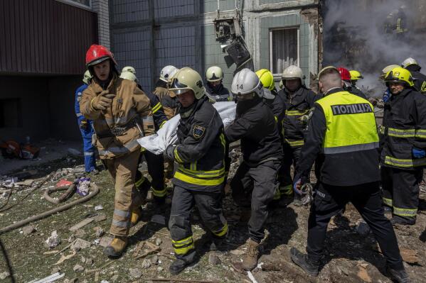 Firefighters carry a body recovered from the rubble of a residential building that was hit during a Russian attack in Uman, central Ukraine, Friday, April 28, 2023. (AP Photo/Bernat Armangue)