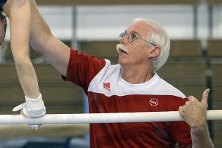 CORRECTS TO MISCONDUCT ALLEGATIONS AND REMOVES GYMNAST REFERENCE - In this June 30, 2016 photo, coach John Holman works with a gymnast at Parkettes National Gymnastics Training Center in Allentown, Pa. Holman, who has coached for about 40 years at Parkettes Gymnastics Club, has been barred by USA Gymnastics from being around minors unsupervised while it investigates a misconduct claim. USA Gymnastics tells The Allentown Morning Call that Holman's suspension, issued by the U.S. Center for SafeSport, is a requirement when such allegations are reported. (Emily Paine/The Morning Call via AP)
