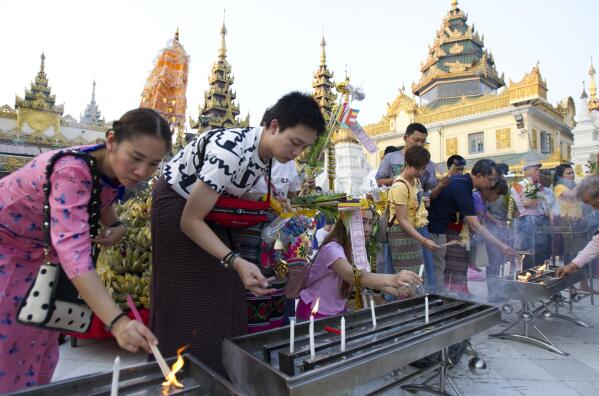 FILE - Foreign tourists offer joss sticks as they visit Myanmar famous Shwedagon Pagoda in Yangon, Myanmar Sunday, April 28, 2019. Myanmar has announced it will recommence issuing tourist visas beginning May 15, 2022, in an effort to help its moribund tourism industry, devastated by the coronavirus pandemic and violent political unrest. (AP Photo/Thein Zaw, File)