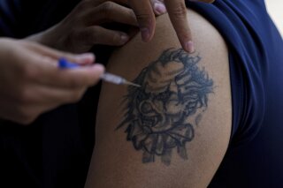 FILE - A youth gets a shot of Russia's Sputnik V coronavirus vaccine during a vaccination drive at University Stadium in Mexico City, Friday, July 23, 2021. Four out of five people in Mexico who got influenza shots so far this year turned down the government’s recommendation they get Russian or Cuban COVID-19 boosters at the same time, officials said Tuesday, Nov. 21, 2023. (AP Photo/Fernando Llano, File)