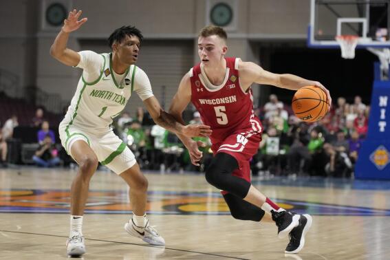 Wisconsin's Tyler Wahl (5) drives arouns North Texas' Aaron Scott (1) during the second half of an NCAA college basketball game in the semifinals of the NIT, Tuesday, March 28, 2023, in Las Vegas. (AP Photo/John Locher)
