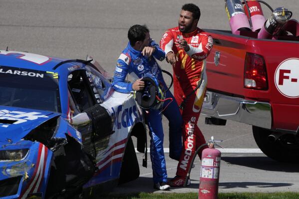 Bubba Wallace, right, pushes Kyle Larson after the two crashed during a NASCAR Cup Series auto race Sunday, Oct. 16, 2022, in Las Vegas. (AP Photo/John Locher)