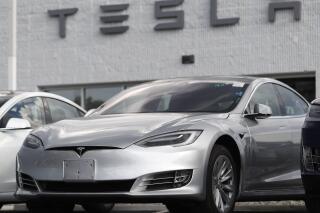 FILE - This July 8, 2018, file  photo shows Tesla 2018 Model 3 sedans sitting on display outside a Tesla showroom in Littleton, Colo. The U.S. government has opened a formal investigation into Tesla's Autopilot partially automated driving system, saying it has trouble spotting parked emergency vehicles. The National Highway Traffic Safety Administration announced the action Monday, Aug. 16, 2021, in a posting on its website. (AP Photo/David Zalubowsi, File)