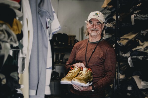 This photo provided by the Portland Rescue Mission shows James Free posing for a photo with a pair of of gold Nike Air Jordan 3 sneakers at the Portland Rescue Mission on Sunday, Oct. 30, 2023, in Portland, Ore. The sneakers, designed in 2019 for filmmaker Spike Lee, that were donated to the homeless shelter, sold for nearly $51,000 at auction on Monday, Dec. 18. (Aaron Ankrom/Portland Rescue Mission via AP)