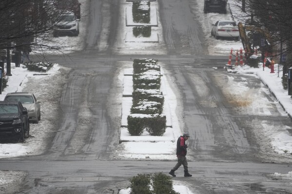 A person crosses Deadrick St., Thursday, Jan. 18, 2024, in Nashville, Tenn. A snowstorm blanketed the area with up to eight inches of snow and frigid temperatures. (AP Photo/George Walker IV)