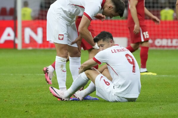 Poland's Robert Lewandowski, bottom, reacts during the international friendly soccer match between Poland and Turkey at the National stadium in Warsaw, Poland, Monday, June 10, 2024. (AP Photo/Czarek Sokolowski)