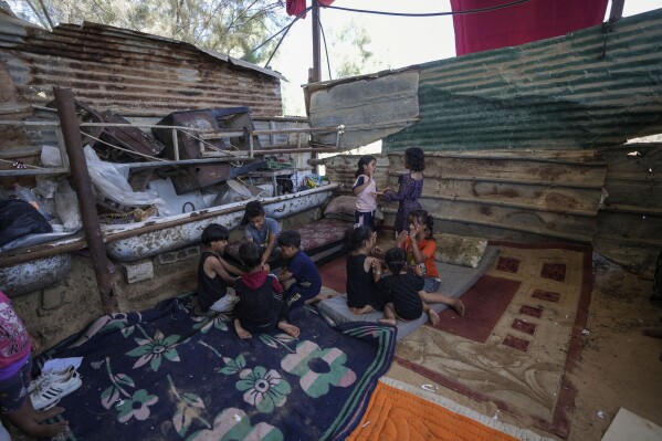 Palestinian children play in Khan Younis, Gaza Strip, Monday, June 10, 2024. (AP Photo/Abdel Kareem Hana)