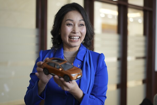 Vinfast CEO Le Thi Thu Thuy holds up a miniature model of a Vinfast car in Hanoi, Vietnam, on Sept. 29, 2023. Vietnamese automaker Vinfast has plunged right into the crowded and hypercompetitive U.S. auto market, gambling that if it can sell its electric vehicles to finicky Americans, it can succeed anywhere. So far, that gamble has yet to pay off. (AP Photo/Hau Dinh)