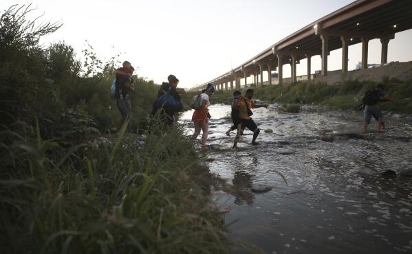 FILE - Venezuelan migrants walk across the Rio Bravo towards the United States border to surrender to the border patrol, from Ciudad Juarez, Mexico, Oct. 13, 2022. A surge in migration from Venezuela, Cuba and Nicaragua in September brought the number of illegal crossings to the highest level ever recorded in a fiscal year, according to U.S. Customs and Border Protection. (AP Photo/Christian Chavez, File)