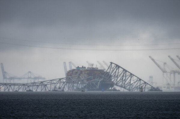 Clouds float over the Patapsco River near the container ship Dali, owned by Grace Ocean PTE, as it rests against wreckage of the Francis Scott Key Bridge on Wednesday, March 27, 2024, as seen from Pasadena, Md. (AP Photo/Alex Brandon)