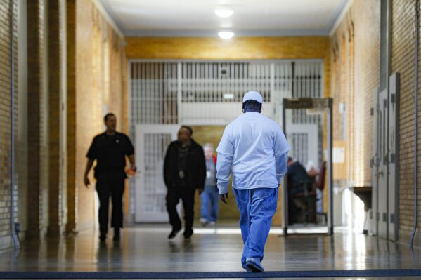 Myon Burrell, convicted in the murder of Tyesha Edwards, an 11-year-old girl pierced in the heart by a stray bullet in 2002 while doing homework at her family's dining room table, walks back to his cellblock at the Stillwater Correctional Facility, Wednesday, Oct. 23, 2019, in Stillwater, Minn. Burrell, convicted with no gun, fingerprints or hard evidence implicating him, has drawn a growing number of legal experts, community leaders and civil rights activists who are worried that the black teenager may have been wrongly convicted. (AP Photo/John Minchillo)