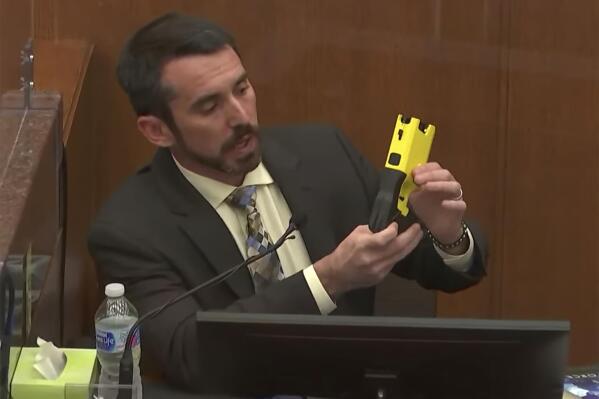 In this screen grab taken from video, Seth Stoughton, associate law professor at the University of South Carolina, shows a Taser to the jury as he testifies as Hennepin County Judge Regina Chu presides over court Wednesday, Dec. 15, 2021, in the trial of former Brooklyn Center police Officer Kim Potter in the April 11, 2021, death of Daunte Wright, at the Hennepin County Courthouse in Minneapolis. (Court TV, via AP, Pool)