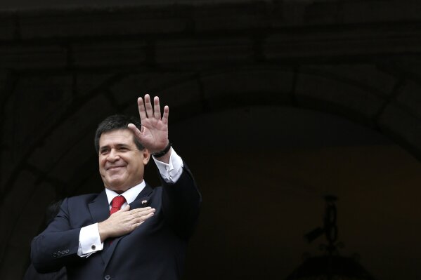 
              FILE - In this Nov. 21, 2014 file photo, Paraguay's President Horacio Cartes waves from a government palace balcony, in Quito, Ecuador. President Cartes said Monday, April 17, 2017, that he will not be a candidate in the 2018 election even if Congress approves a constitutional amendment to allow a second term. (AP Photo/Dolores Ochoa, File)
            