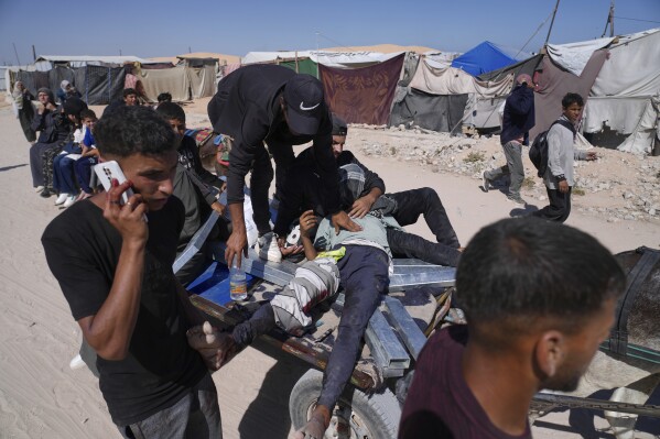 Palestinians carry an injured man after he was shot at an aid distribution center run by the Gaza Humanitarian Foundation a U.S.-backed organization approved by Israel in Khan Younis, southern Gaza Strip, on Thursday, May 29, 2025. (AP Photo/Abdel Kareem Hana)