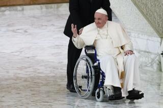 ARCHIVO - El papa Francisco llega en silla de ruedas a una audiencia con monjas y líderes religiosos en el Vaticano, el 5 de mayo de 2022. (AP Foto/Alessandra Tarantino, archivo)